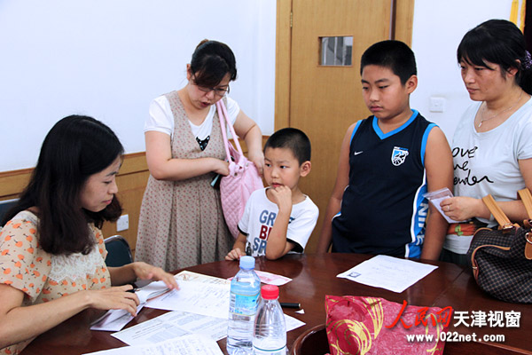 家长带参赛小选手前来进行2012天津市小提琴展演暨演奏比赛报名认证（摄影/廖晓莉）