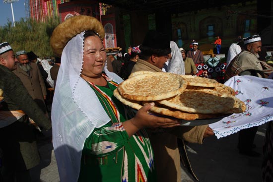 拿着馕叫卖的维吾尔族妇女