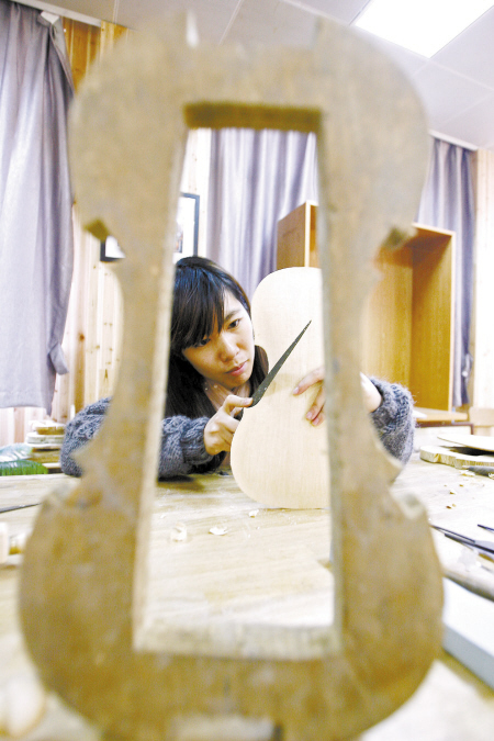 大一学生邵璐调整打磨背板。