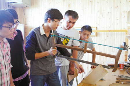 意大利籍提琴制作师刘朝阳（拿锯者）指导学生挑选和切割木材。