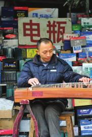 付书明正在门口弹琴。