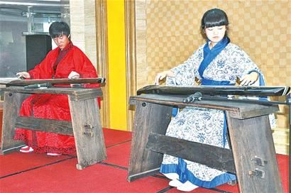 昨日，两名身穿汉服的艺术生在为观众抚琴。