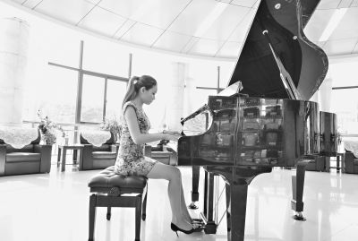 昨日，杨文婷在武昌殡仪馆接待中心大厅弹奏钢琴