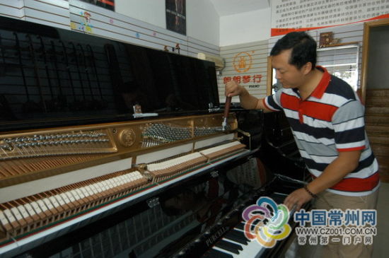 畅杰在给钢琴调音。张海韵 摄