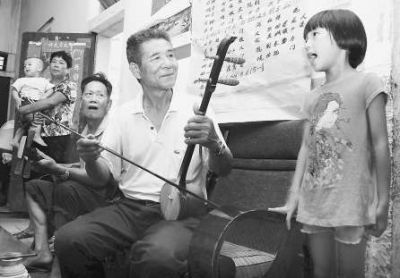 闲暇时光，林朱法和老伙伴拉起弦乐，孙女唱段北管乐曲，一家人其乐融融。