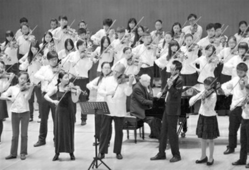 敏茨一排中与学生共奏《练声曲》。本报记者 叶辰亮摄