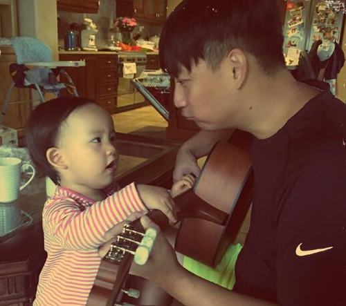 黄磊抱吉他与二女儿合影，温馨十足