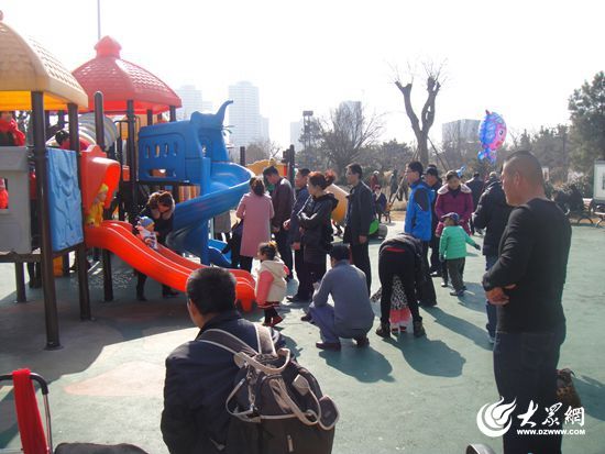 儿童游乐园里细心照看孩子的家长