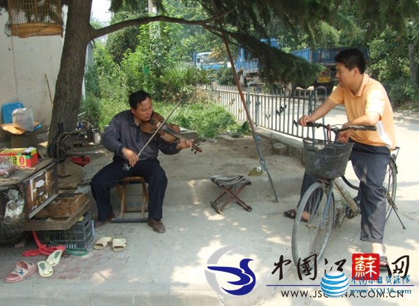 街头修鞋摊有位“提琴哥” 坚持梦想数十年不放弃