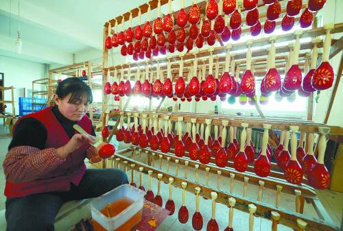 11月23日，永信实业有限公司工人在给沙球上色。